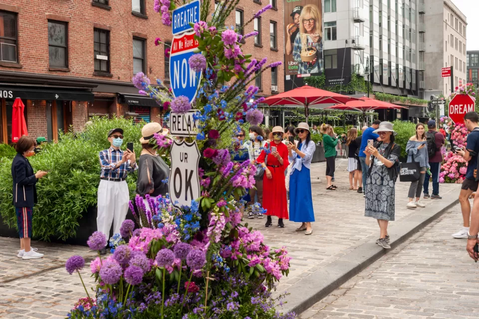 People gather on a street with no cars during the L.E.A.F. Festival of Flowers in the Meatpacking District of New York City.